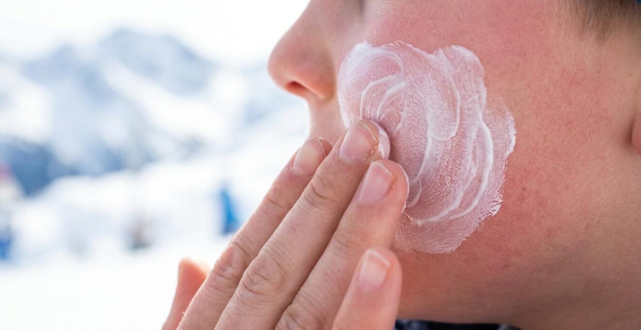 Gros plan sur l'application de crème solaire sur le visage d'un enfant en montagne